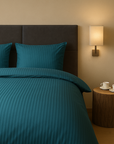 Luxe dekbedovertrekset van katoen-satijn in blauw kleur, opgemaakt op een hotelwaardig bed