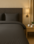 Luxe dekbedovertrekset van katoen-satijn in zwart kleur, opgemaakt op een hotelwaardig bed