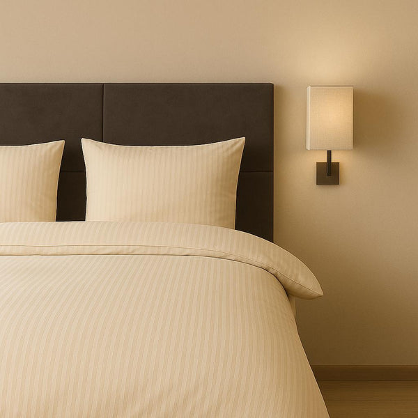 Luxe dekbedovertrekset van katoen-satijn in zand kleur, opgemaakt op een hotelwaardig bed