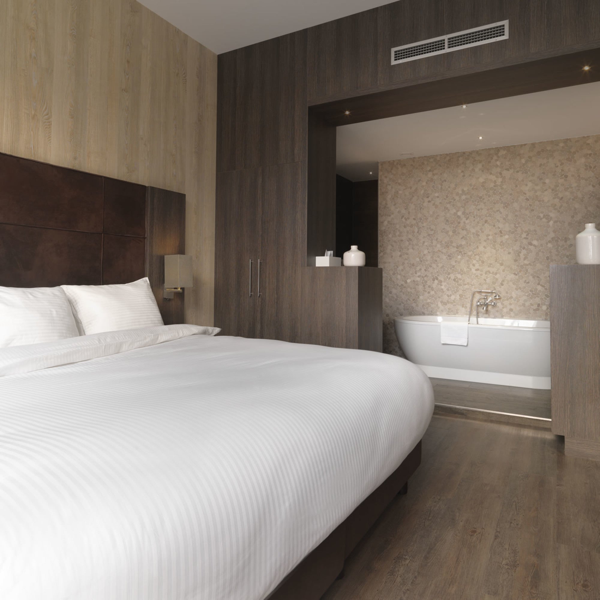 Luxe dekbedovertrekset van katoen-satijn in wit kleur, opgemaakt op een hotelwaardig bed