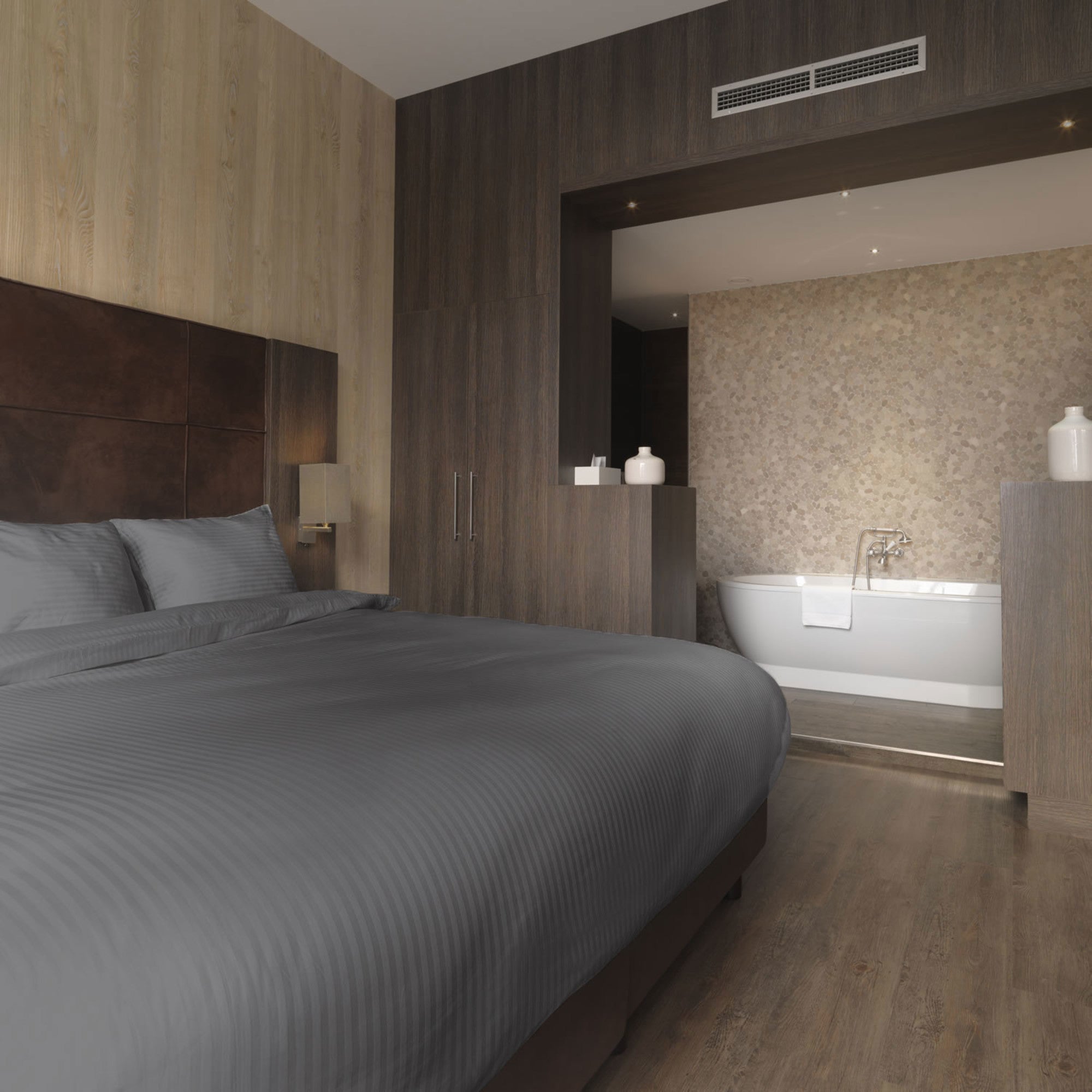 Luxe dekbedovertrekset van katoen-satijn in grijs kleur, opgemaakt op een hotelwaardig bed