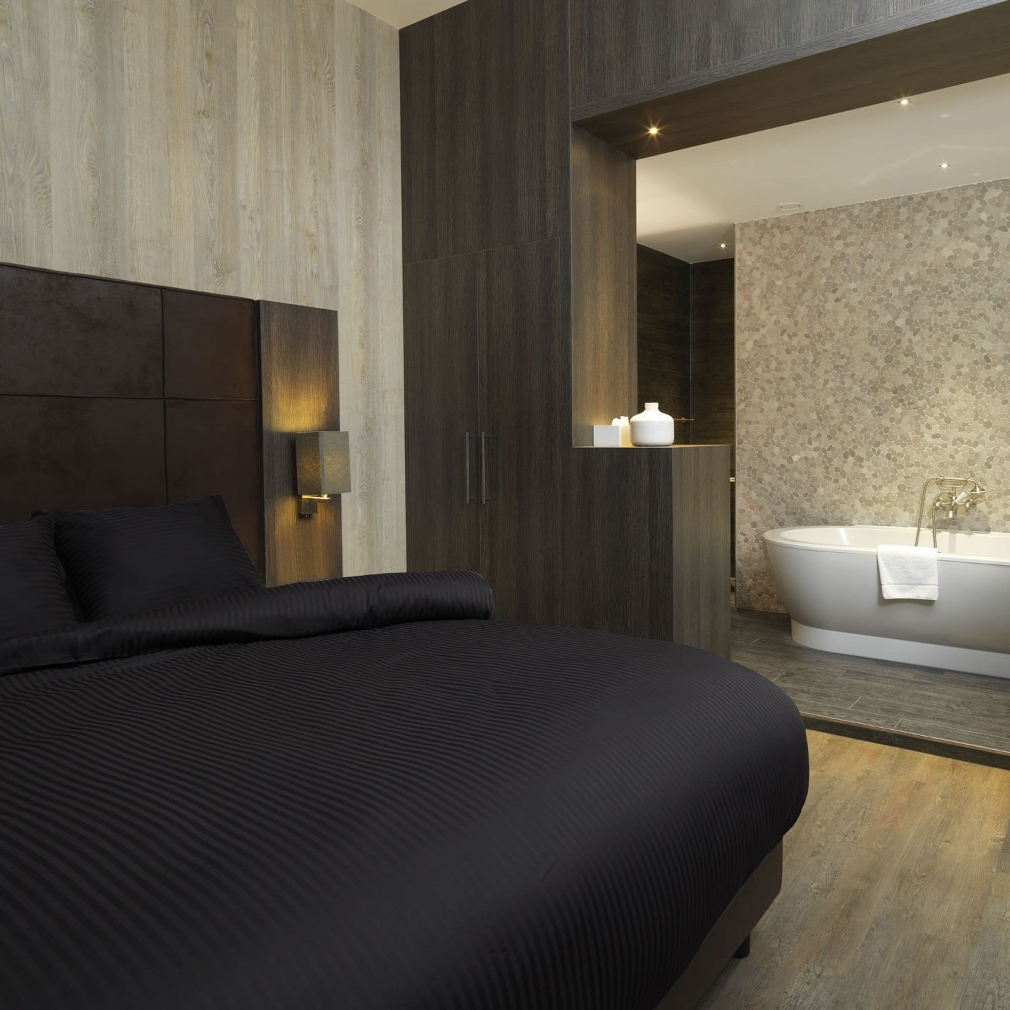 Luxe dekbedovertrekset van katoen-satijn in zwart kleur, opgemaakt op een hotelwaardig bed