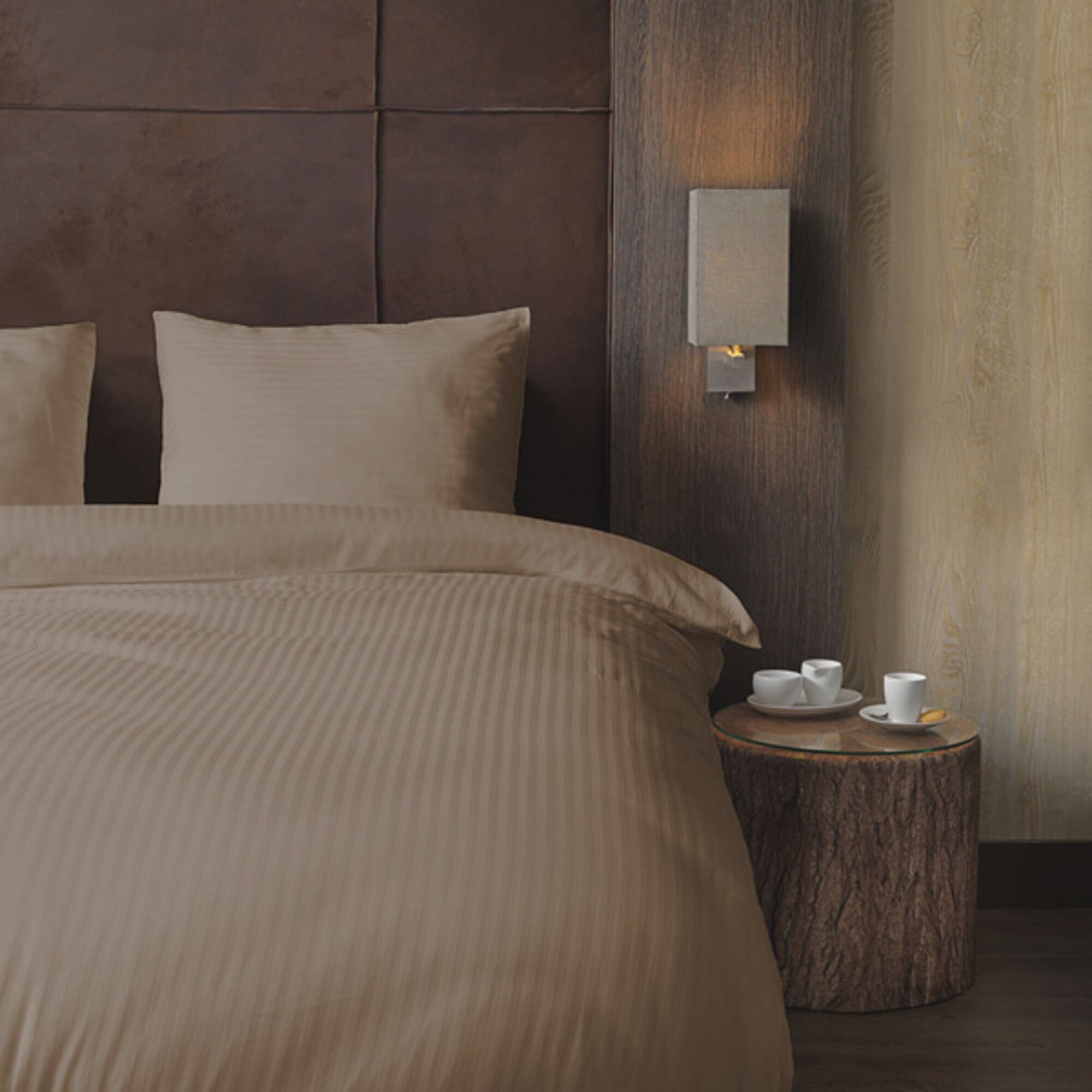 Luxe dekbedovertrekset van katoen-satijn in taupe kleur, opgemaakt op een hotelwaardig bed